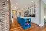 Kitchen featuring sink, blue cabinetry, light hardwood / wood-style flooring, white cabinets, and an island with sink