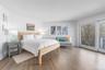 Bedroom featuring baseboards, access to exterior, and wood finished floors