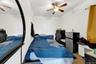 Bedroom featuring a ceiling fan and freestanding refrigerator