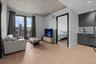 Living room with light wood-style floors and a wall mounted air conditioner