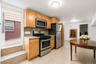 Compact kitchen featuring light wood cabinetry and stainless steel appliances