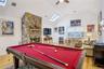 Recreation room featuring a skylight, a fireplace, vaulted ceiling, and light wood-type flooring