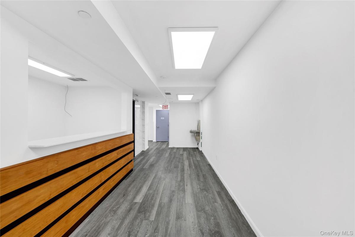 Hallway with baseboards and wood finished floors