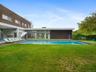 Swimming pool featuring a patio and a lawn