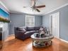 Living room featuring light wood-style floors, ornamental molding, and ceiling fan