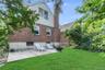 Back of property featuring a patio area, a lawn, brick siding, and a chimney