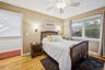 Bedroom featuring light wood-style floors, a skylight, and ceiling fan