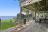 Deck featuring a water view, a lawn, and outdoor dining area