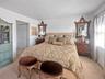 Bedroom with a baseboard radiator, a closet, and light colored carpet
