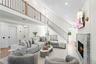 Living room featuring a fireplace, stairway, recessed lighting, wood finished floors, and a towering ceiling