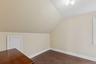 Bonus room with lofted ceiling and dark wood finished floors