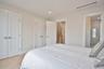 Bedroom with light wood finished floors, two closets, and recessed lighting