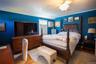 Bedroom with wood finished floors, ceiling fan, an AC wall unit, and crown molding