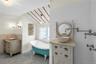 Bathroom featuring a clawfoot tub, recessed shelving, and a window for natural light
