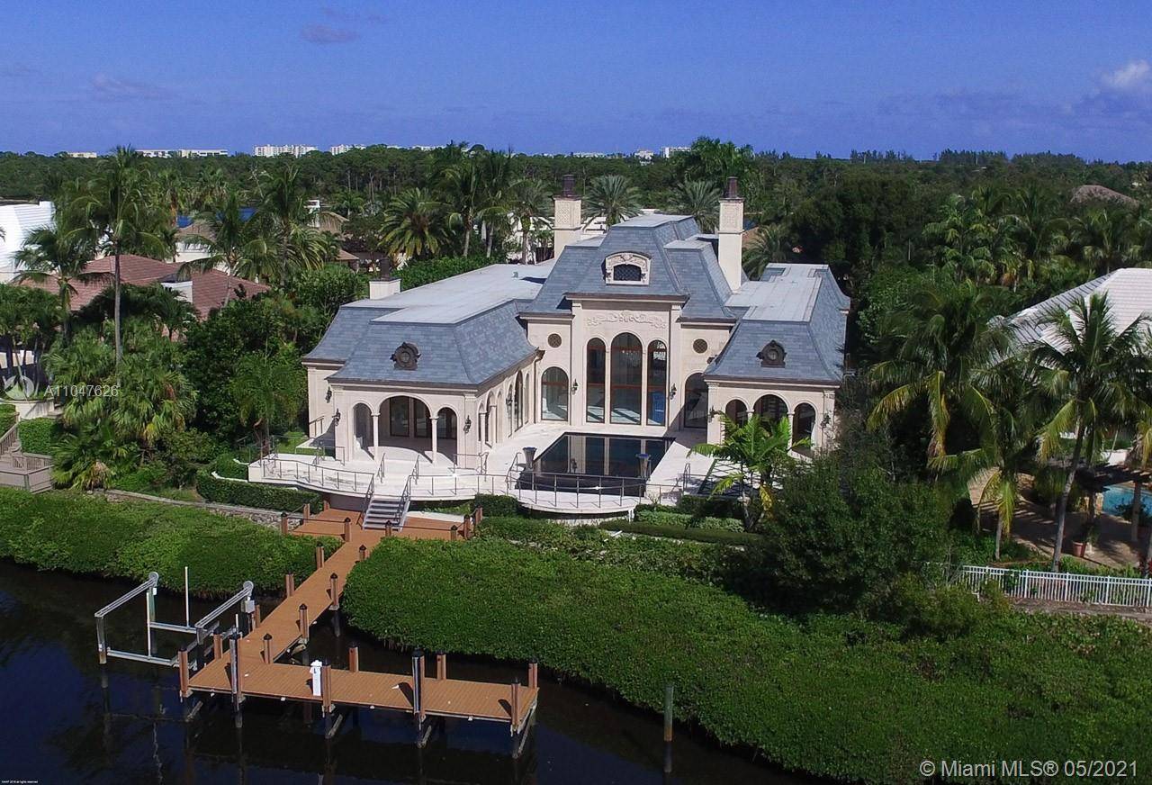 Modern elegance meets traditional style throughout in this stunning French Chateau inspired waterfront home in the prestigious Admiral Cove.