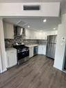 Kitchen featuring stainless steel appliances, white cabinetry, exhaust hood, decorative backsplash, and recessed lighting