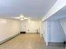 Finished basement featuring a baseboard radiator and light tile patterned floors