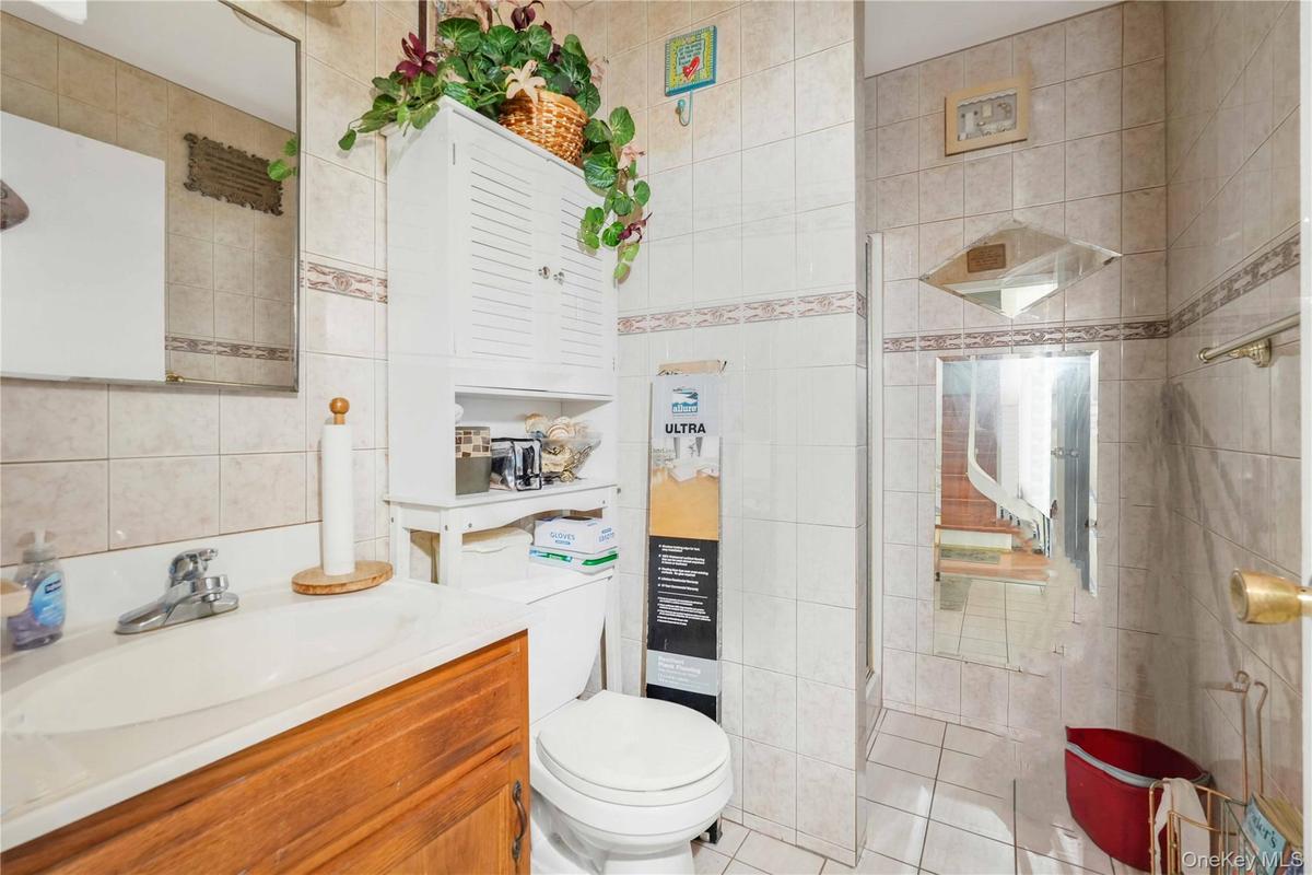 Full bath with tile walls, vanity, and tile patterned flooring