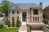French country inspired facade with french doors, brick siding, a garage, and a balcony