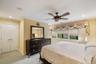 Recessed lighting, crown molding, and a ceiling fan fixture complement the room's design