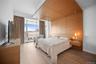 Bedroom with a wall of windows and light wood-type flooring