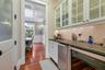 Bar featuring coffered ceiling, sink, beam ceiling, white cabinets, and wine cooler