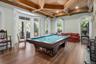 Playroom with billiards table, beam ceiling, coffered ceiling, dark wood finished floors, and crown molding