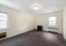 Spare room with radiator, dark carpet, and a wall mounted AC