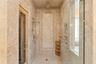 The main-level primary suite serves as a private retreat, featuring a spa-inspired marble ensuite bath with Phylrich fixtures, a large sauna, soaking