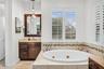 Primary bathroom with dual vanities, spa tub, toilet closet and walk-in shower