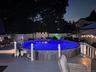 Backyard featuring a built-in pool, expansive multi-level decking, and perimeter fencing