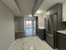 Kitchen featuring light marble finish flooring, freestanding refrigerator, modern cabinets, and open floor plan