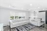 Living area featuring recessed lighting, a multi-window wall with blinds, dark wood-finish flooring, and a modern chandelier