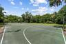 Community basketball court surrounded by green space.
