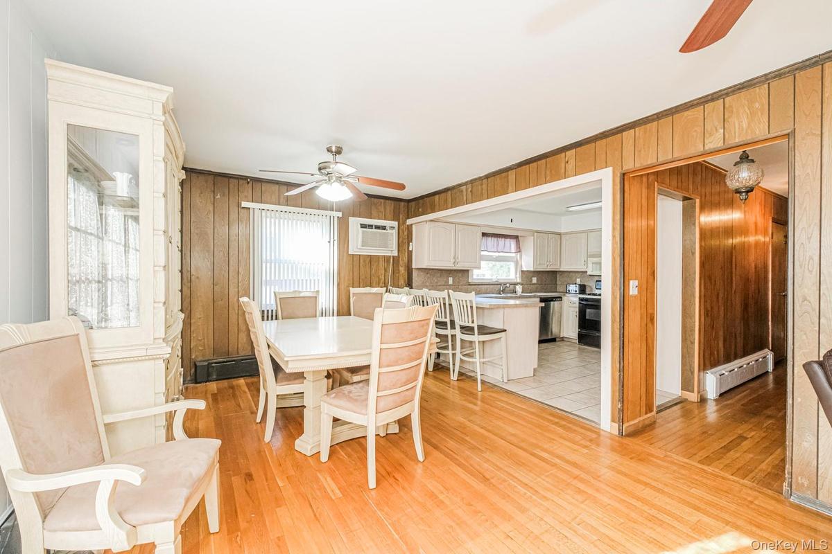 Dining area with wood-finish flooring and paneled walls