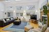 Living room with a towering ceiling, hardwood / wood-style floors, a fireplace, and a skylight