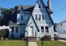 Distinctive Tudor Revival-style residence featuring a prominent front-facing gable and textured stucco siding