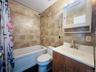 Full bathroom featuring tile walls, vanity, and shower / bath combination with curtain