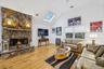 Game room with a stone fireplace, a skylight, lofted ceiling, and wood finished floors
