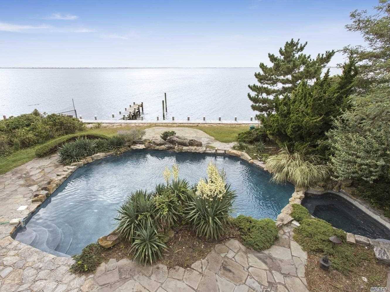 This stately traditional home with endless views of Moriches Bay offers a custom gunite bayside pool overlooking Cupsogue Beach and luxurious, tranquil, and spacious accommodations.