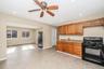 Kitchen featuring black appliances, brown cabinets, light countertops, recessed lighting, and a baseboard heating unit
