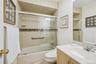 Bathroom featuring vanity and shower / bath combination with glass door