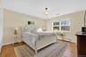 Bedroom with baseboard heating and light wood finished floors