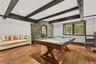 Sophisticated timber beams and a custom stonework accent wall frame a private, temperature-controlled wine cellar. This refined billiards lounge offer