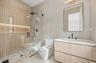 Full bathroom featuring tile walls, a stall shower, and vanity
