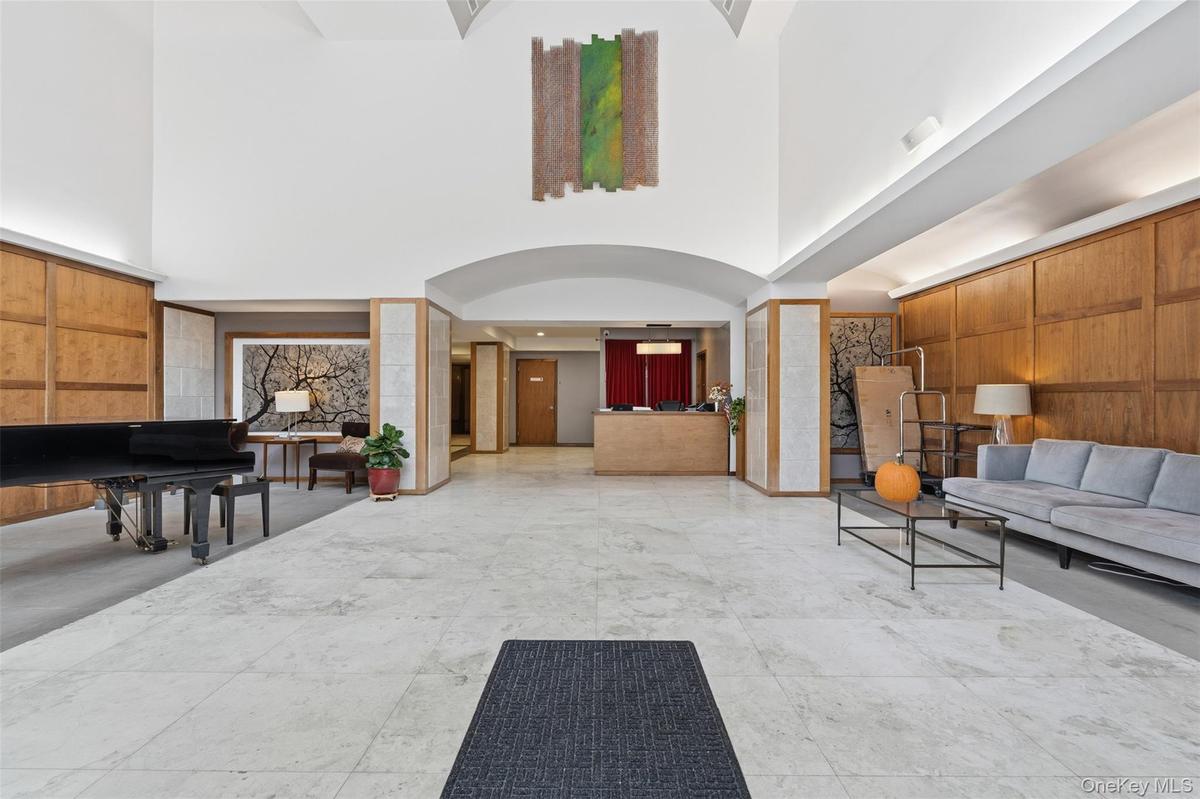 Spacious lobby with light-toned tile flooring and wood paneling
