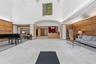 Spacious lobby with light-toned tile flooring and wood paneling