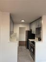 Kitchen featuring gray cabinetry, baseboards, light countertops, range, and a sink