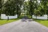 Mature oak trees and beautifully landscaped grounds create a private entrance to the property