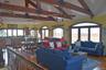 Living area featuring beamed ceiling, a ceiling fan, wood finished floors, and high vaulted ceiling